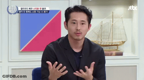 A Man With A Beard Is Talking In Front Of A Jtbc Sign GIF