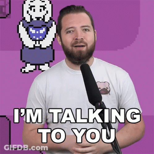 A Man With A Beard Is Talking Into A Microphone With The Words I 'M Talking To You Below Him GIF