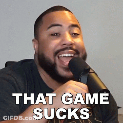 A Man With A Beard Is Talking Into A Microphone With The Words That Game Sucks Below Him GIF