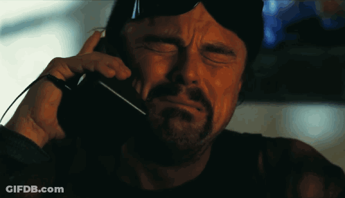 A Man With A Beard Is Talking On A Cellphone GIF