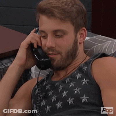 A Man With A Beard Is Talking On A Phone With Pop Written On The Bottom Of His Shirt GIF