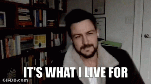 A Man With A Beard Is Talking On A Video Call In Front Of A Bookshelf . GIF