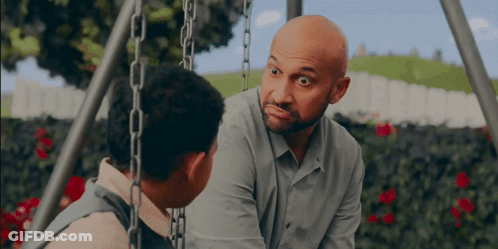 A Man With A Beard Is Talking To A Boy On A Swing Set GIF