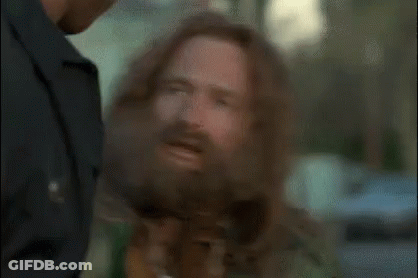 A Man With A Beard Is Talking To A Police Officer . GIF