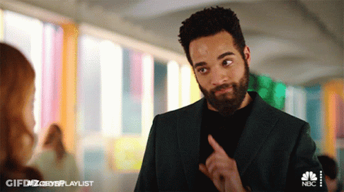 A Man With A Beard Is Talking To A Woman In A Hallway With #Zoeysplaylist On The Bottom GIF