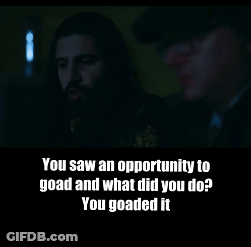 A Man With A Beard Is Talking To Another Man In A Dark Room GIF