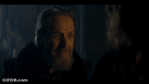 A Man With A Beard Is Talking To Another Man In A Dark Room . GIF