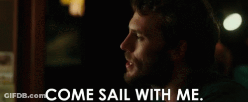 A Man With A Beard Is Talking To Another Man In A Dark Room . GIF