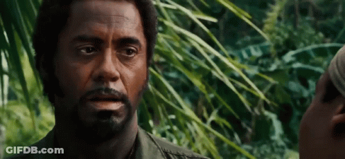 A Man With A Beard Is Talking To Another Man In A Forest . GIF