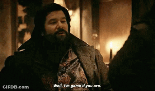 A Man With A Beard Is Talking To Another Man In A Room With A Candle . GIF