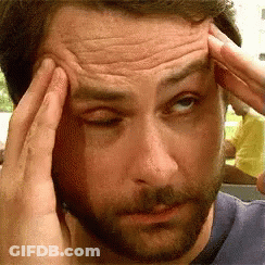 A Man With A Beard Is Touching His Forehead With His Hands GIF