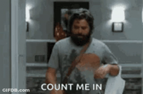 A Man With A Beard Is Walking Down A Hallway And Saying `` Count Me In '' While Holding A Bag . GIF