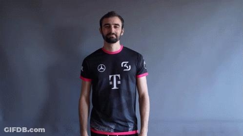 A Man With A Beard Is Wearing A Black And Pink Shirt With The Letter T On It GIF