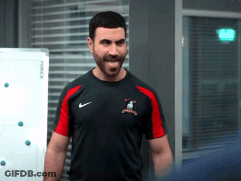 A Man With A Beard Is Wearing A Black And Red Nike Shirt . GIF