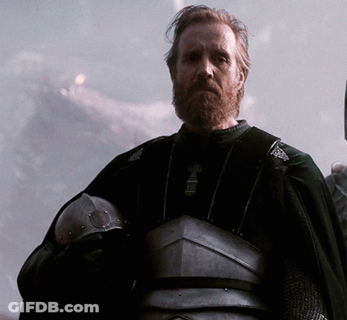 A Man With A Beard Is Wearing A Black Cape And Armor GIF