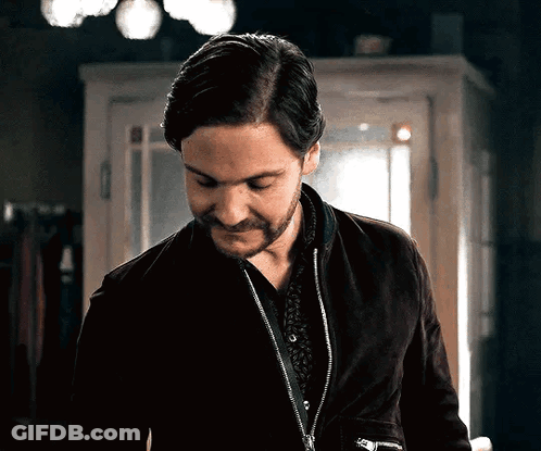 A Man With A Beard Is Wearing A Black Jacket And A Black Shirt GIF