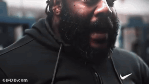 A Man With A Beard Is Wearing A Black Nike Jacket GIF