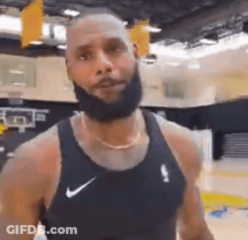 A Man With A Beard Is Wearing A Black Nike Tank Top . GIF