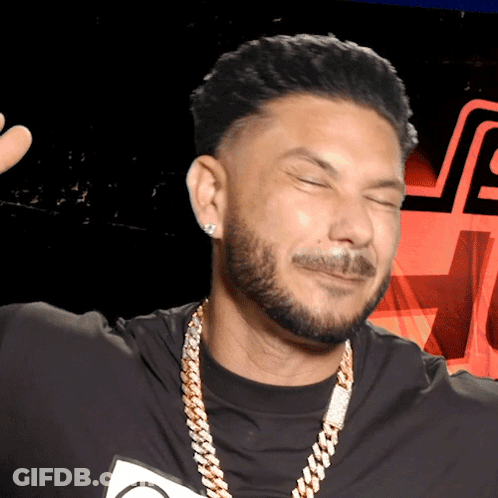 A Man With A Beard Is Wearing A Black Shirt And A Gold Chain GIF