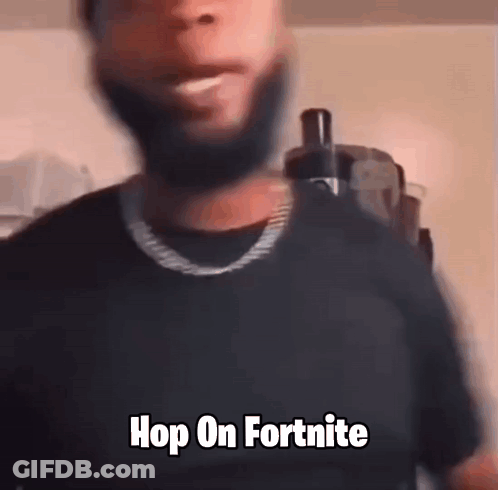 A Man With A Beard Is Wearing A Black Shirt And A Gold Chain . GIF