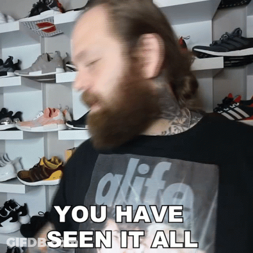 A Man With A Beard Is Wearing A Black Shirt That Says Alife GIF