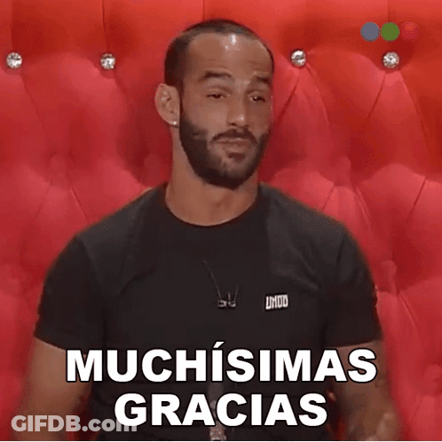 A Man With A Beard Is Wearing A Black Shirt That Says Muchisimas Gracias On It GIF
