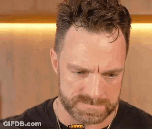 A Man With A Beard Is Wearing A Black Shirt That Says ' Rude ' On The Collar GIF