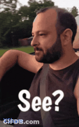 A Man With A Beard Is Wearing A Black Shirt That Says See On It GIF