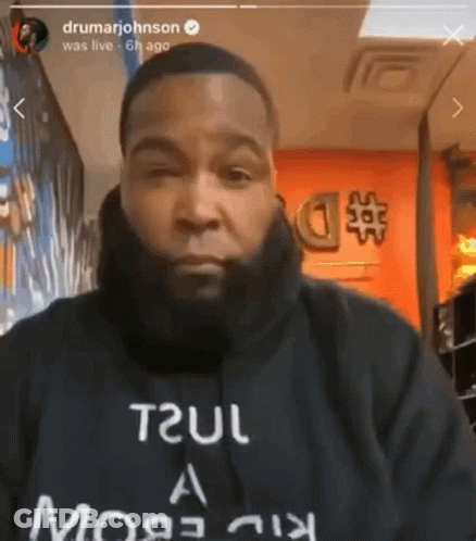 A Man With A Beard Is Wearing A Black Shirt That Says Trul GIF