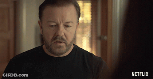 A Man With A Beard Is Wearing A Black Shirt With A Netflix Logo On The Bottom GIF