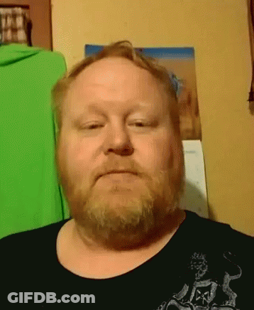 A Man With A Beard Is Wearing A Black Shirt With A Skull And Crossbones On It GIF