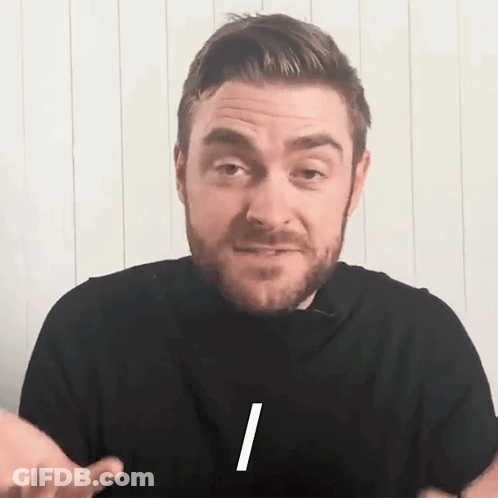 A Man With A Beard Is Wearing A Black Shirt With The Letter I On The Front GIF