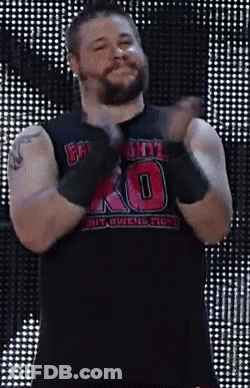 A Man With A Beard Is Wearing A Black Tank Top With The Number 10 On It And Gloves . GIF