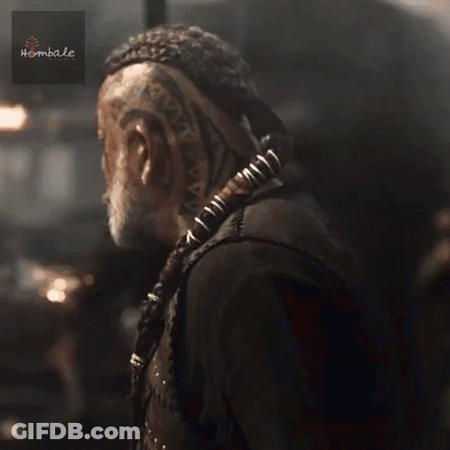 A Man With A Beard Is Wearing A Black Vest With Studs And A Sticker That Says Hembale GIF