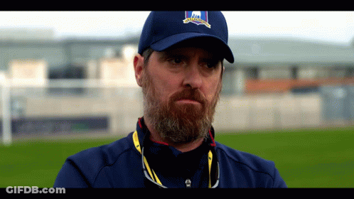 A Man With A Beard Is Wearing A Blue Hat That Says ' Ireland ' On It GIF