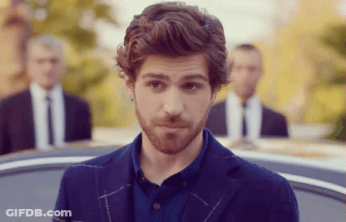 A Man With A Beard Is Wearing A Blue Jacket And A Blue Shirt GIF