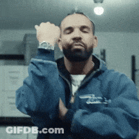 A Man With A Beard Is Wearing A Blue Jacket With The Letter T On It GIF