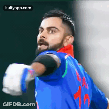 A Man With A Beard Is Wearing A Blue Jersey With The Number 15 On It . GIF
