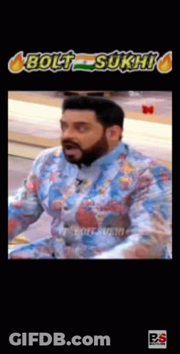 A Man With A Beard Is Wearing A Blue Shirt With A Floral Pattern And Making A Funny Face . GIF