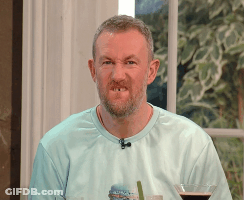 A Man With A Beard Is Wearing A Blue Shirt With A Microphone On His Neck GIF