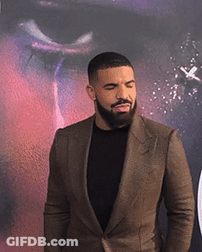 A Man With A Beard Is Wearing A Brown Suit GIF