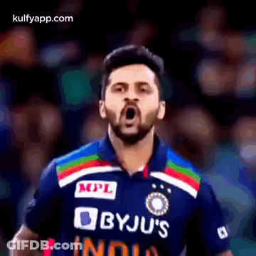 A Man With A Beard Is Wearing A Byju 'S India Jersey And Making A Funny Face . GIF