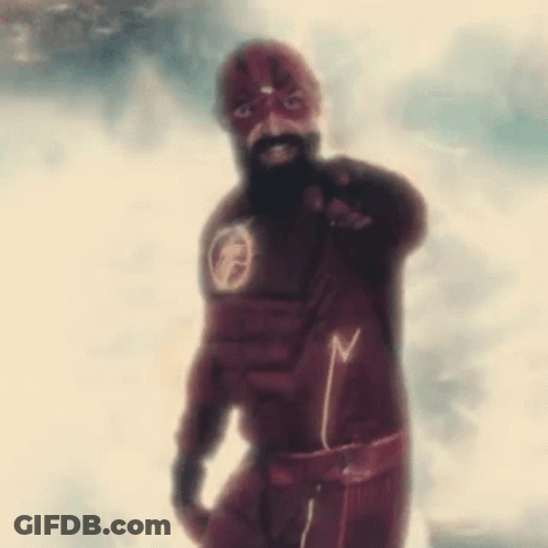 A Man With A Beard Is Wearing A Flash Suit And Pointing . GIF
