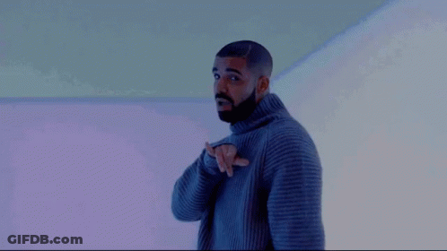 A Man With A Beard Is Wearing A Gray Sweater And Pointing At Something . GIF