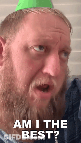 A Man With A Beard Is Wearing A Green Party Hat And Says Am I The Best GIF