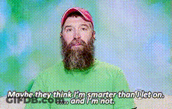 A Man With A Beard Is Wearing A Green Shirt And Red Hat GIF