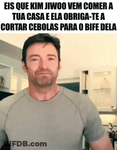 A Man With A Beard Is Wearing A Grey Shirt With A Caption That Reads Eis Que Kim Jiwoo Vem Comer GIF