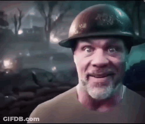 A Man With A Beard Is Wearing A Hard Hat And Smiling . GIF