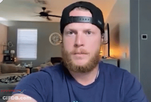 A Man With A Beard Is Wearing A Hat And A Blue Shirt That Says Hyperx On It GIF