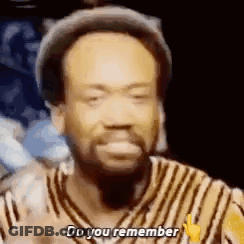 A Man With A Beard Is Wearing A Hat And A Striped Shirt And Is Saying `` Do You Remember '' . GIF